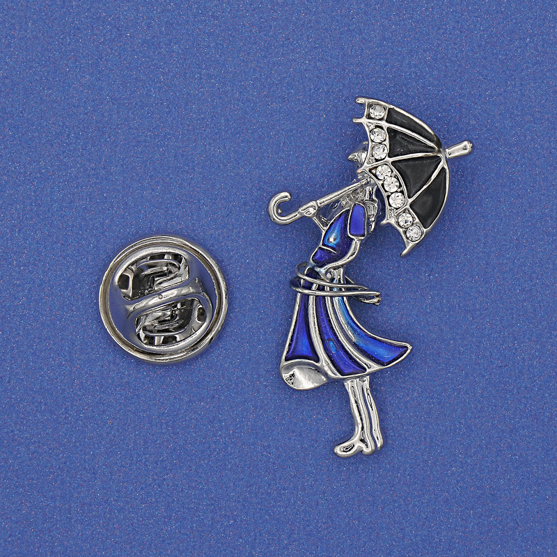 Broche «Fille avec parapluie» — strass blancs, émail bleu, métal doré, 32×16 mm+