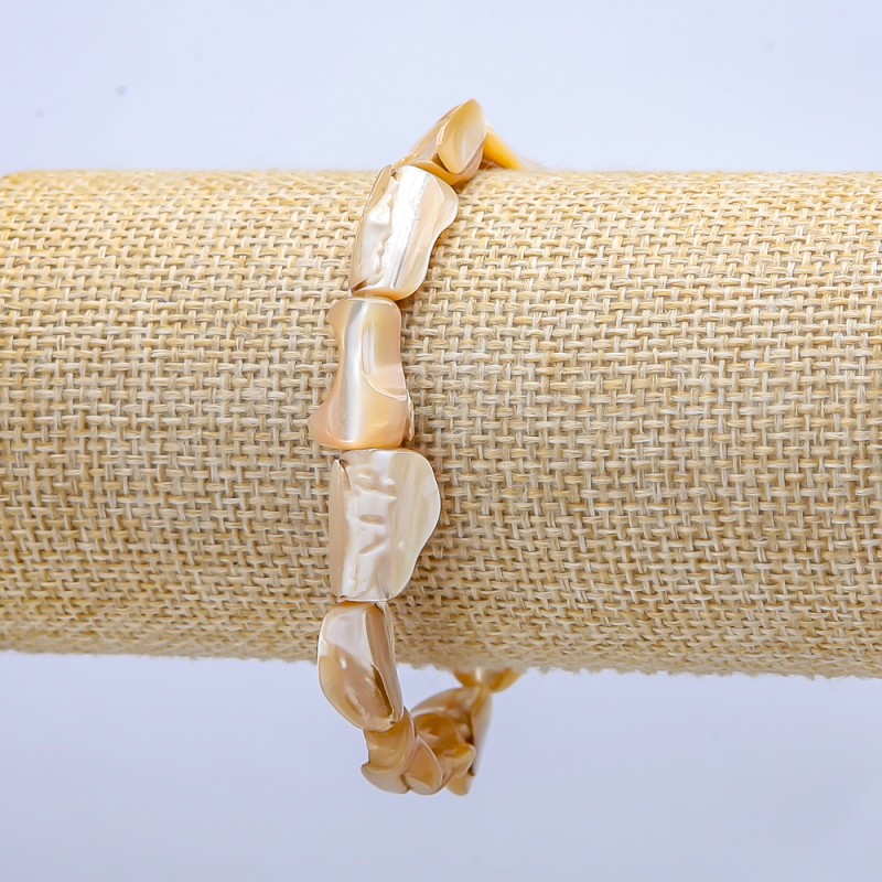 Bracelet élastique en nacre naturelle beige. Perles nacrées facettées, diamètre environ 15 × 12 mm, longueur 18 cm (+/-)