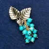 Broche avec pierre variscite «Brindille avec des baies», couleur dorée du métal 60×35 mm