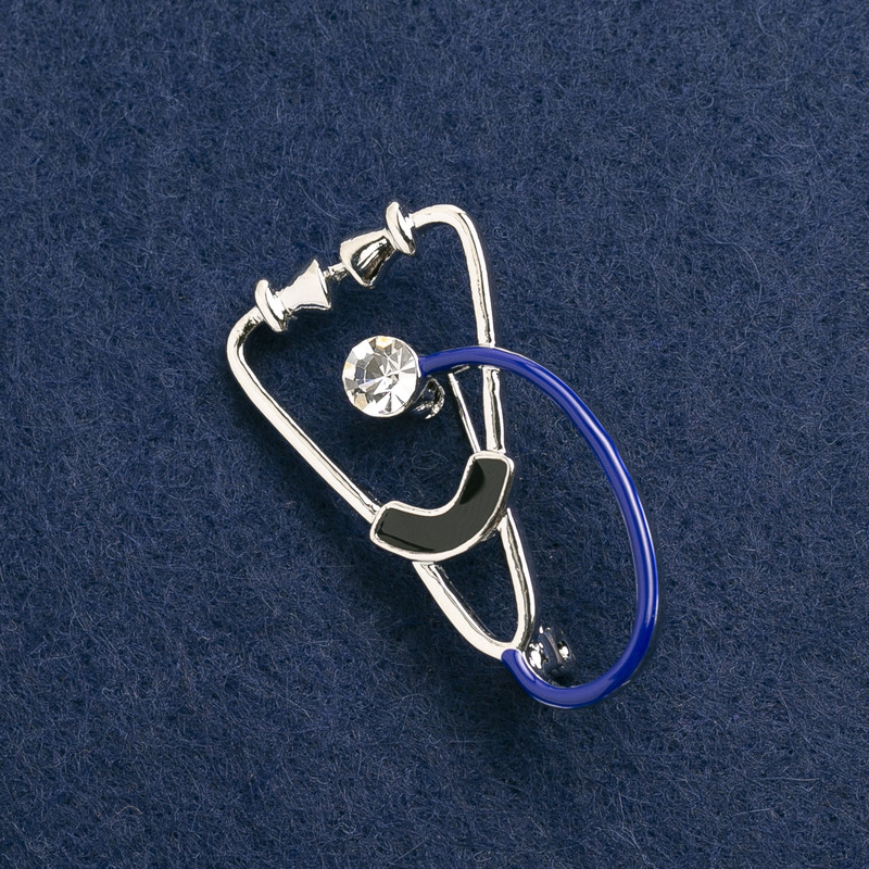 Broche stéthoscope émail noir et bleu, avec pierre blanche, métal argenté 43×24 mm